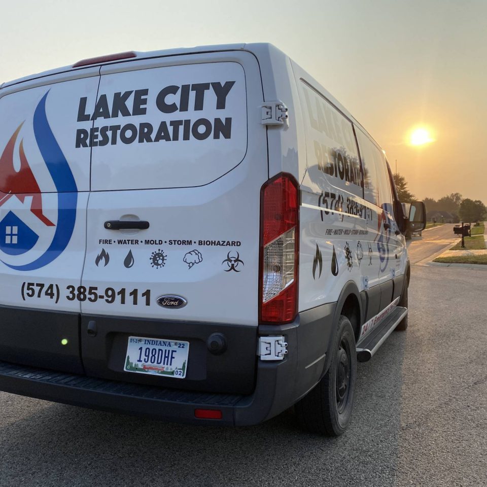 Lake City Restoration van bathed in sunset glow on the roadside.